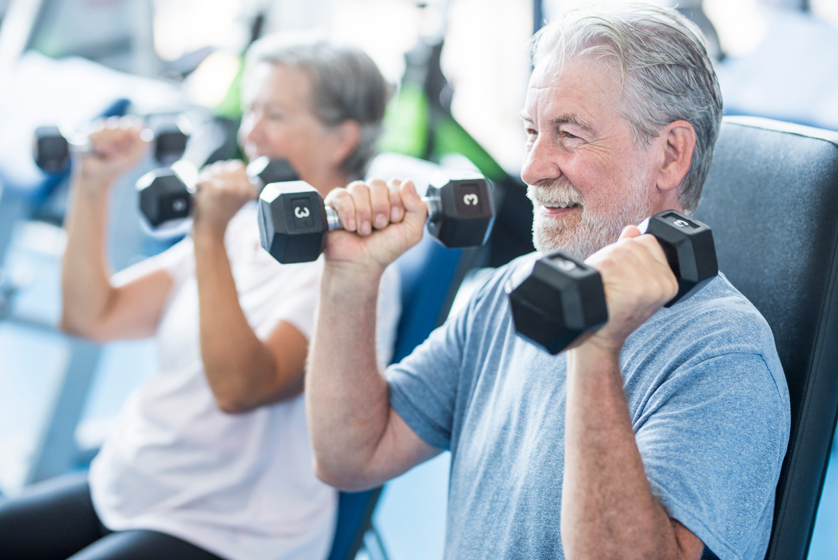 Senior Couple Doing Exercise of Biceps at the Gym